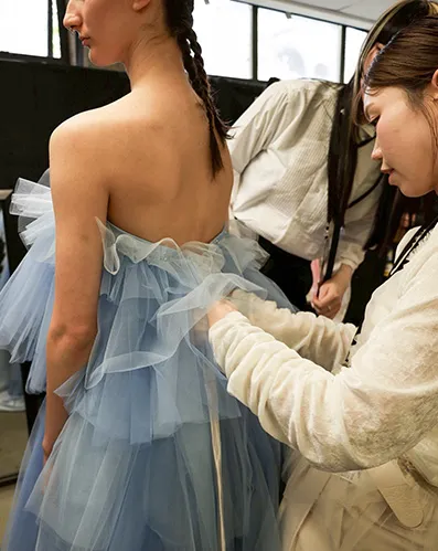 控え室でブルーのチュールドレスのお支度をしているモデルさんと、aim aimmeスタッフの様子